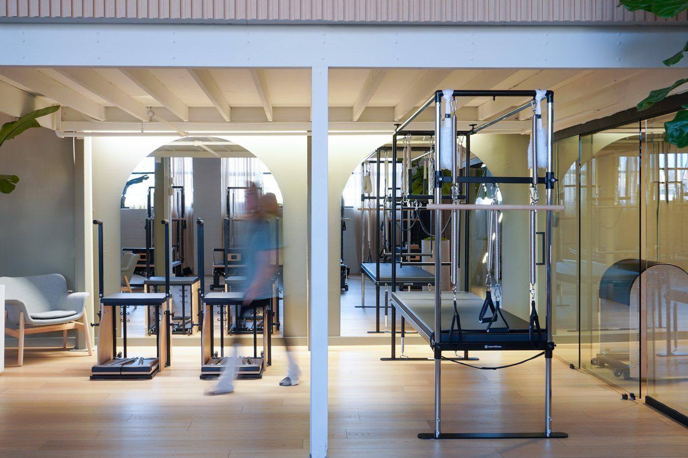 The Leaside Pilates studio with arches, Cadillac trapeze table, and glass private rooms